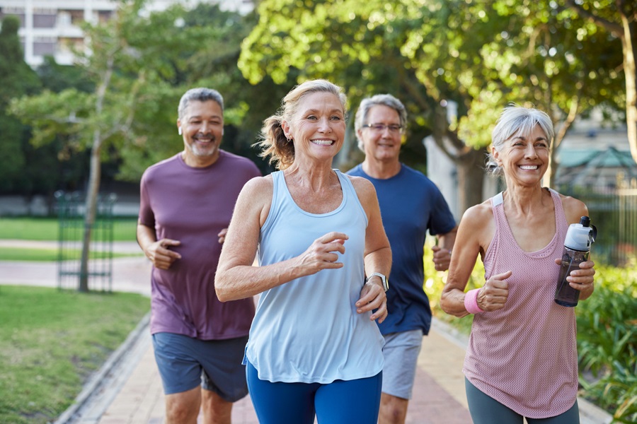 Group of older adults running together outdoors.