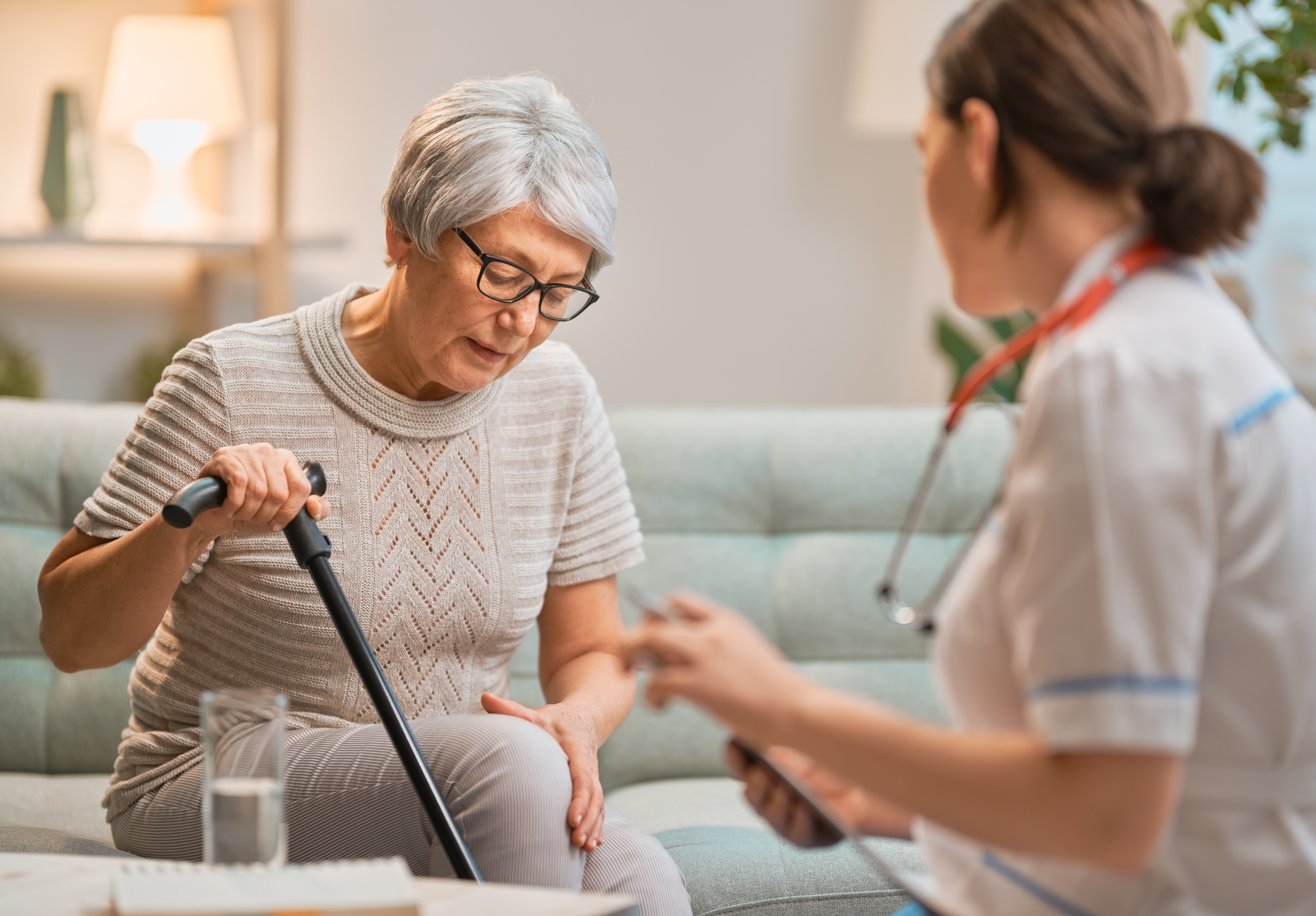 Older adult woman describing pain in knee to a healthcare professional
