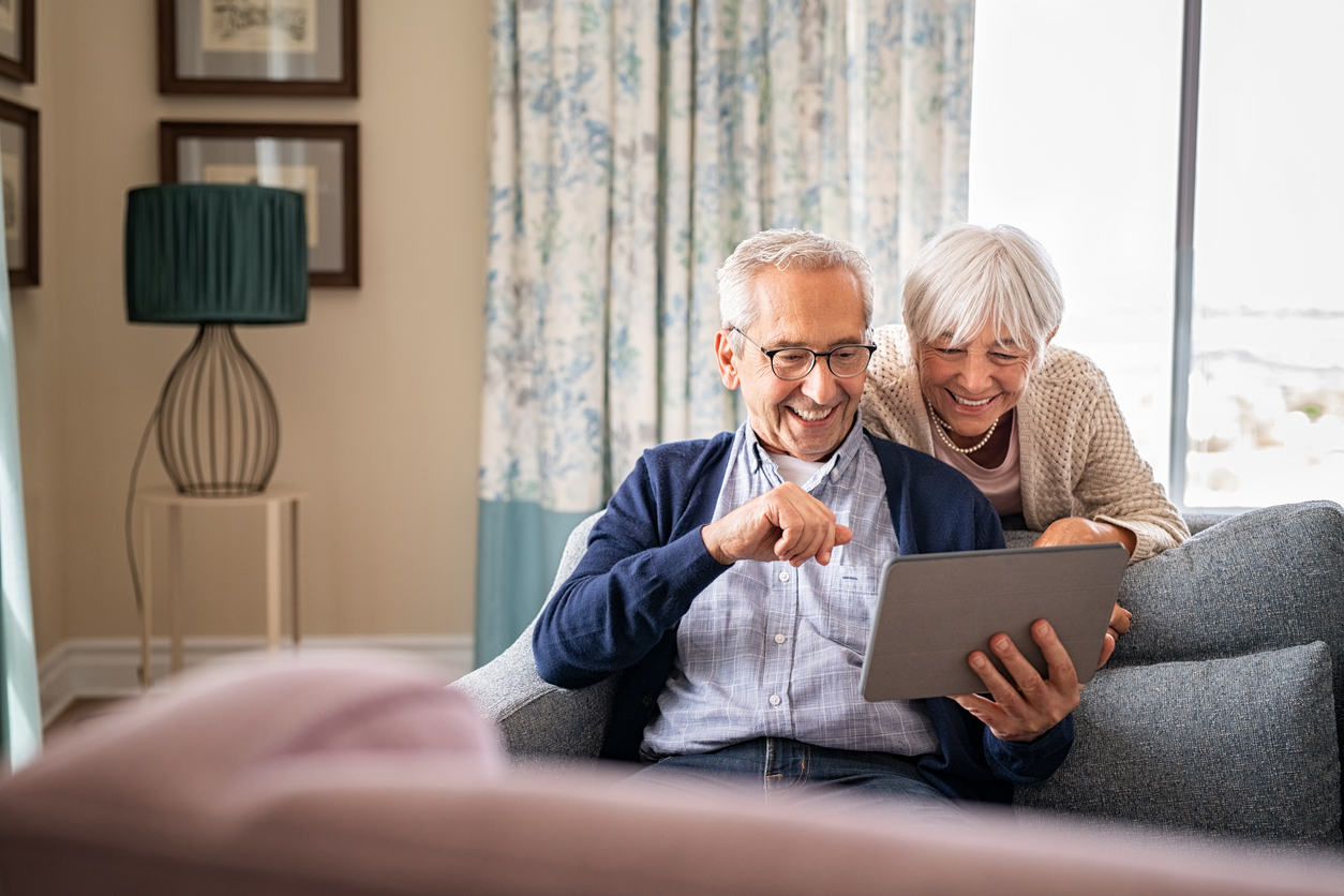 Older couple smiling looking at tablet